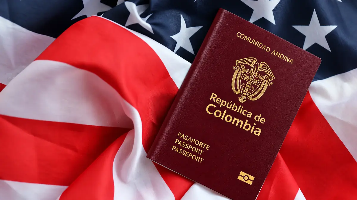 Pasaporte colombiano sobre la bandera de Estados Unidos